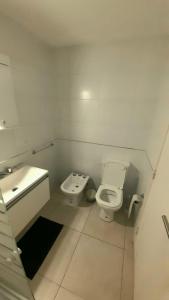 Imagine Depto في لا بلاتا: حمام أبيض مع مرحاض ومغسلة