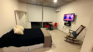 Imagine Depto في لا بلاتا: غرفة نوم مع سرير وتلفزيون بشاشة مسطحة +12 صورة