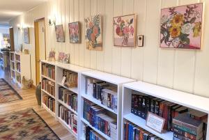 une bibliothèque avec des étagères blanches remplies de livres dans l'établissement Wisteria Guest House, à Ganges