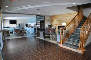 eine Lobby mit einer Treppe und einem Esszimmer in der Unterkunft Country Inn & Suites by Radisson, Topeka West, KS in Topeka