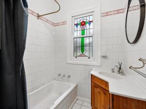a bathroom with a tub and a sink and a window at 'YANALEN COTTAGE' in Myrtleford +9 photos