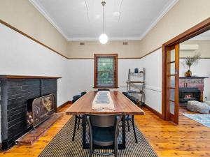 a dining room with a table and a fireplace at 'YANALEN COTTAGE' in Myrtleford