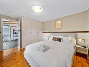 a bedroom with a large white bed in a room at 'YANALEN COTTAGE' in Myrtleford