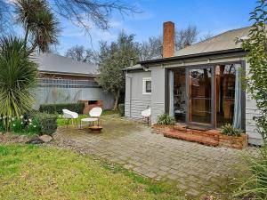 a house with white chairs and a patio at 'YANALEN COTTAGE' in Myrtleford