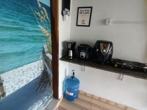 una botella de agua sentada en un estante junto al océano en Chalé da Ana- com cozinha a 80 metros do Rio Preguiça en Barreirinhas