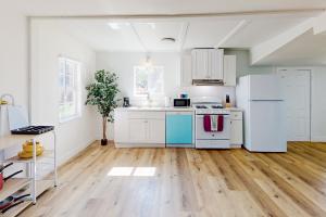 a kitchen with white appliances and wooden floors at Golden Coast Charmer in Riverside