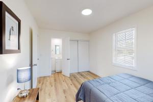 a bedroom with white walls and a bed and a desk at Golden Coast Charmer in Riverside