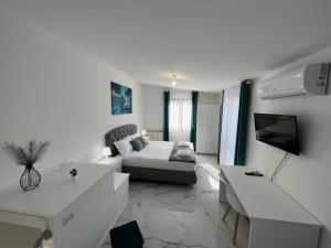 Casa Rodella -SUITE- San Sisto Perugia في بيروجيا: غرفة معيشة بيضاء مع أريكة وتلفزيون