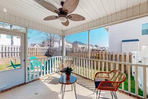 a screened porch with a ceiling fan and chairs and a table at Tranquil Oasis in Cameron