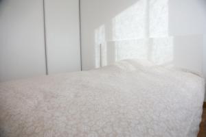 - un lit blanc dans une chambre avec fenêtre dans l'établissement La Suite Est-Versaillais, à Saint-Cyr-lʼÉcole