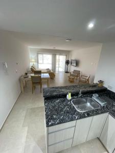 a kitchen with a sink and a living room at Orillas II in Puerto Madryn +15 photos