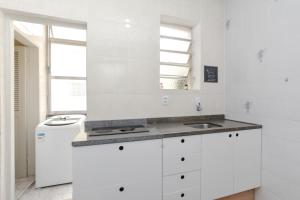 - une cuisine blanche avec un évier et un miroir dans l'établissement Na Cidade Baixa, perto de tudo - UFRGS, Santa Casa, Parques, Orla, à Porto Alegre