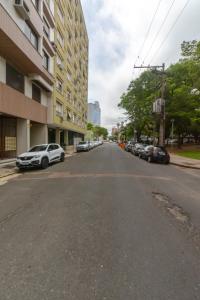 une rue vide avec des voitures garées sur le côté d'un bâtiment dans l'établissement Na Cidade Baixa, perto de tudo - UFRGS, Santa Casa, Parques, Orla, à Porto Alegre