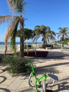 una bicicletta verde parcheggiata su un marciapiede vicino alla spiaggia di Marina di San Lorenzo Guest House a Marina di San Lorenzo
