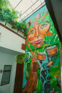 un mural de una mujer en la pared de un edificio en Hostal Pura Vida la 70 en Medellín