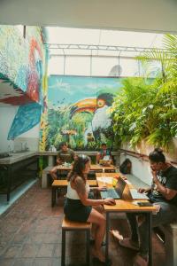 a group of people sitting at tables in a restaurant at Hostal Pura Vida la 70 in Medellín