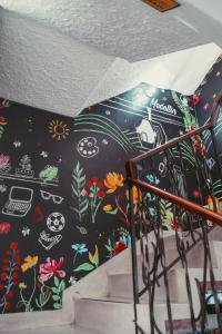 a black umbrella with flowers on it on the stairs at Hostal Pura Vida la 70 in Medellín