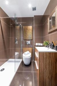 uma casa de banho com um WC, um lavatório e um chuveiro em 3BDR Extremely rare luxury loft maisonette em Londres