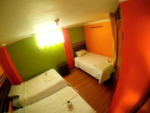 Habitación pequeña con 2 camas y ventana en hostel Punoyork, en Puno