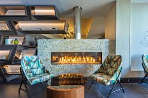 a lobby with a fireplace and two chairs and a table at Renaissance Denver Hotel & Conference Center in Denver
