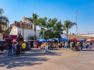 een groep mensen die rondlopen op een markt met paraplu's bij Alojamiento en Morelos in Yecapixtla