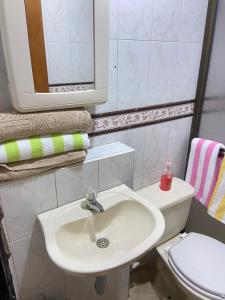 ein Badezimmer mit einem Waschbecken, einem WC und einem Spiegel in der Unterkunft Apartamento Guarne in Guarne
