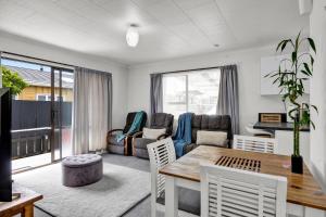 a living room with a table and a couch at New Plymouth Retreat: Beach, Port, Rock & City Nearby. in New Plymouth