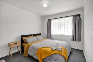 a bedroom with a bed with a stuffed animal on it at New Plymouth Retreat: Beach, Port, Rock & City Nearby. in New Plymouth