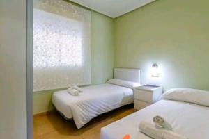 a small bedroom with two beds and a window at Bungalow adaptado, terraza muy grande y soleada. in Gran Alacant +34 photos