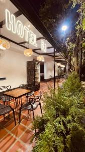 - un restaurant avec des tables et des chaises la nuit dans l'établissement Hotel BJ Curumani, à Curumaní