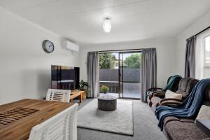 a living room with a couch and a tv at New Plymouth Retreat: Beach, Port, Rock & City Nearby. in New Plymouth