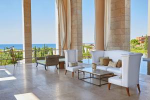 a living room with white furniture and a view of the ocean at The Romanos, a Luxury Collection Resort, Costa Navarino in Romanu