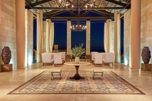 a large room with a table and chairs and a chandelier at The Romanos, a Luxury Collection Resort, Costa Navarino in Romanu