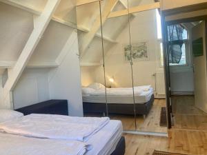 - 2 lits dans une chambre avec un miroir dans l'établissement 8-person house with fitted kitchen, sauna, and beautiful garden, à Oostmahorn