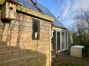 une maison dotée de panneaux solaires sur son côté dans l'établissement 8-person house with fitted kitchen, sauna, and beautiful garden, à Oostmahorn