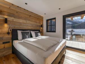 a bedroom with a large bed with a wooden wall at Haus am Hang in Saalbach-Hinterglemm