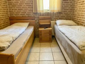 twee bedden in een kamer met een bakstenen muur bij Andrea 4pers workers only home in Anjum in Anjum