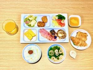 a table with a tray of food and a plate of food at Hotel Sakurano Familia Nago in Nago