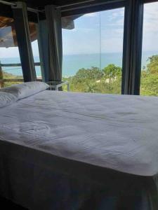a bedroom with a bed with a view of the ocean at Casa Azul da Cor do Mar in Paraty