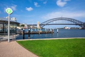 Blick auf eine Brücke über einen Fluss mit einem Grasfeld in der Unterkunft Harbourside #53 in Sydney