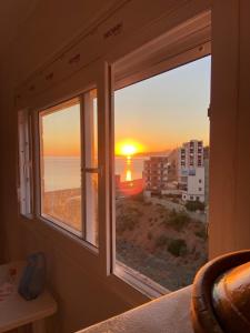 a bedroom window with a view of the sunset at Mon rêve in Douar Chaïb Rasso