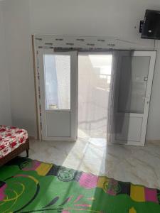 Habitación con 2 puertas correderas de cristal y alfombra. en Mon rêve, en Douar Chaïb Rasso