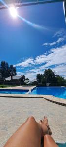 a person laying on the ground next to a swimming pool at Aldea Serrana in Tandil