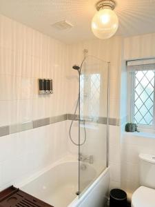 ein Badezimmer mit einer Dusche, einer Badewanne und einem WC in der Unterkunft Vista Lodge in Wythenshawe