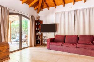 sala de estar con sofá rojo y TV en Quinta family house en Ciudad Lujan de Cuyo