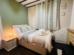 a bedroom with a bed and a window with towels on it at The Naunton Nook in Cheltenham