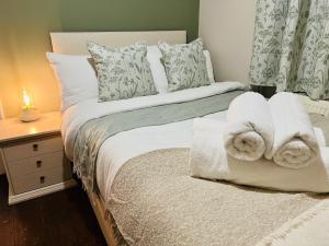 1 dormitorio con 1 cama con toallas en The Naunton Nook en Cheltenham