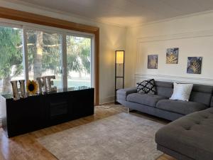 a living room with a couch and a large window at Tranquil Coastal Escape in Port Stanley