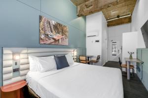 ein Schlafzimmer mit einem weißen Bett und einem Tisch in der Unterkunft The Urban Newtown in Sydney