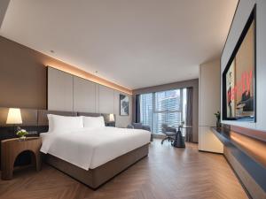 una camera d'albergo con un letto grande e una TV di Hefei Huiyan Anhui Center Intercity Hotel a Hefei